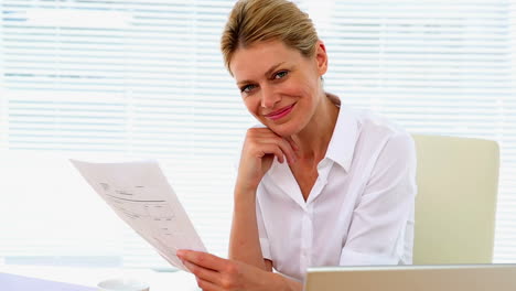 businesswoman reading a document at her desk