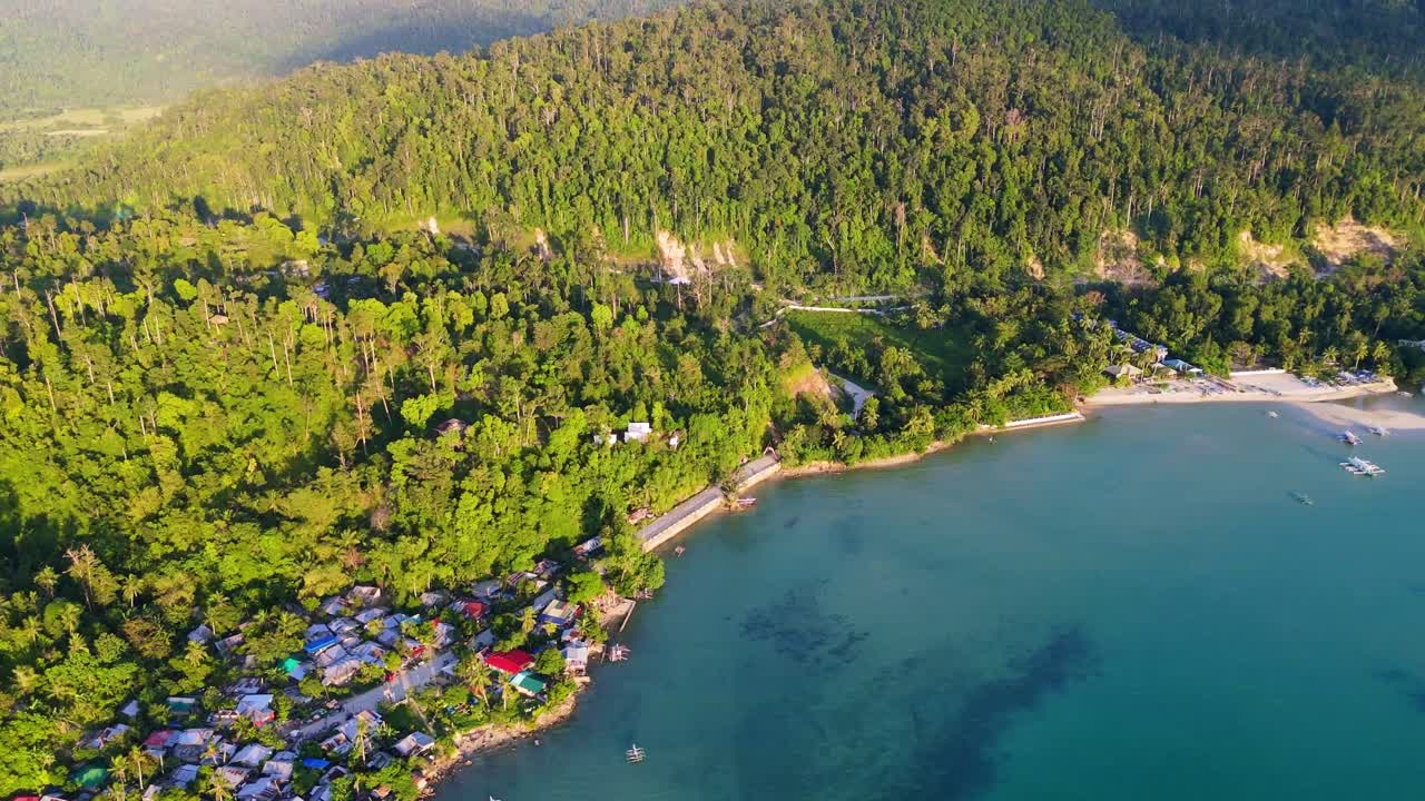 Ripresa con drone della fitta foresta tropicale e delle colline che si affacciano sulle acque turchesi di Port Barton, Palawan. Natura incontaminata nelle Filippine.