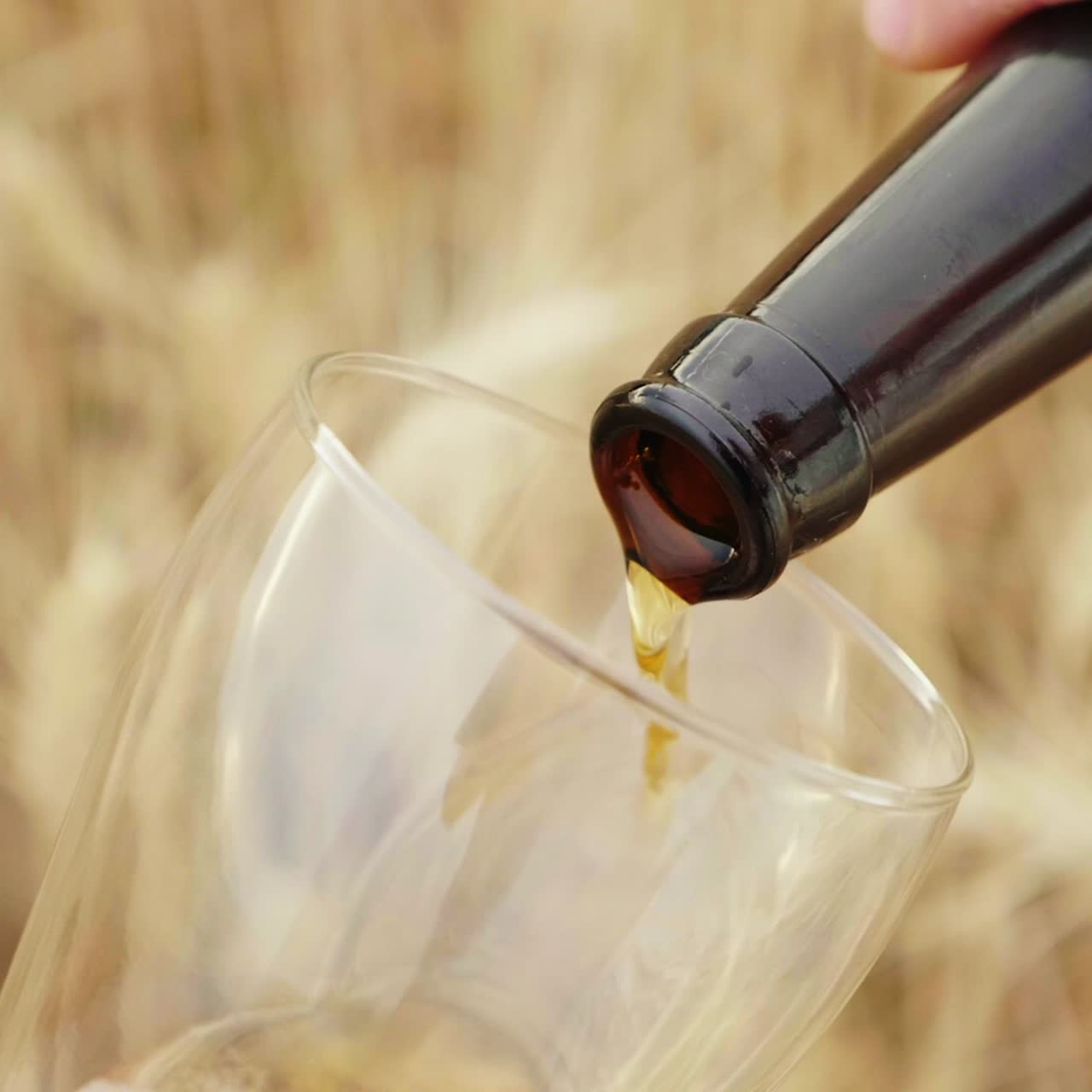 한 남자가 병에서 유리잔으로 맥주를 따른다