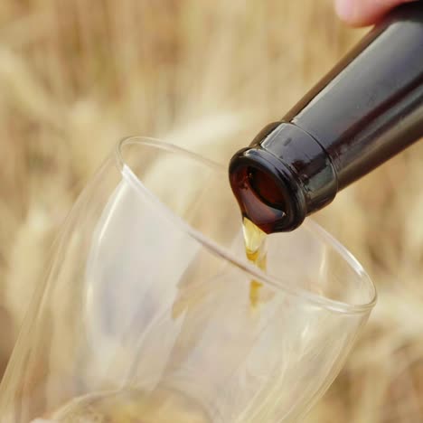 un hombre vierte cerveza de una botella en un vaso