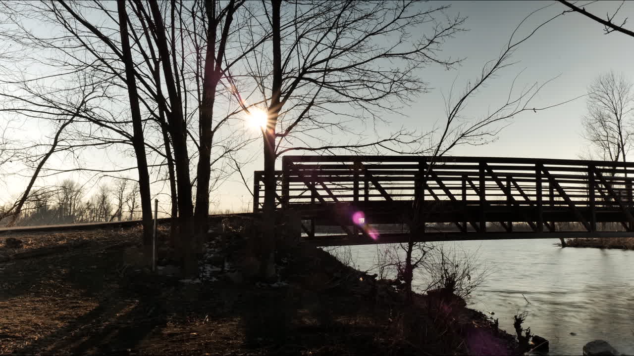 puesta de sol detrás del puente sobre el río. lapso de tiempo