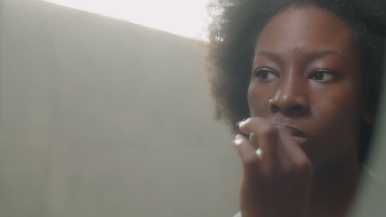 African American Woman Brushing Teeth in Bathroom