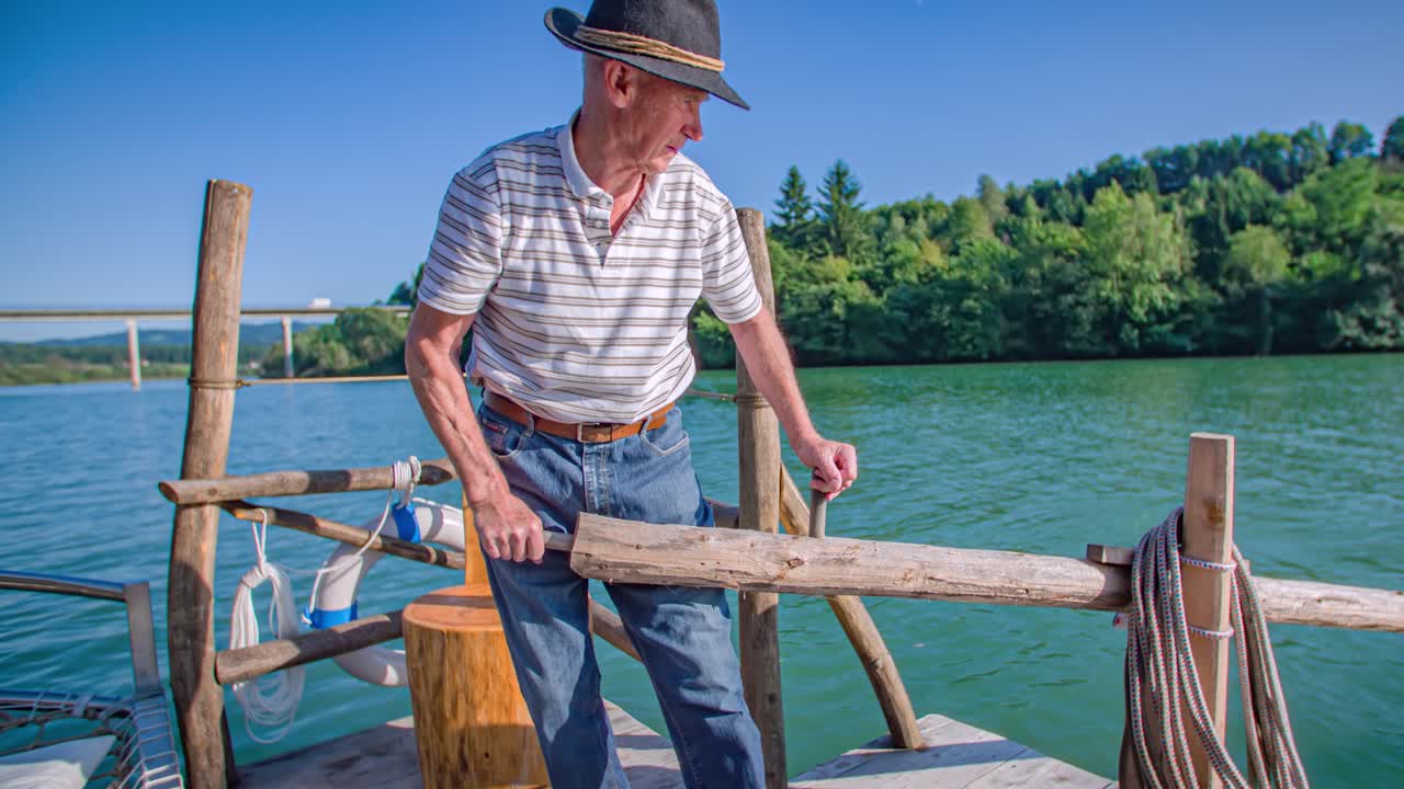 Older adult Caucasian man on wooden log raft and wood oar on river, close up, slomo