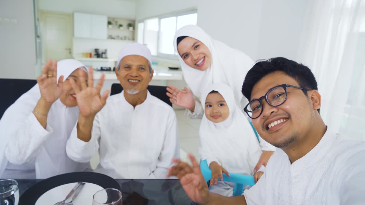 무슬림 가족이 식당에서 비디오 통화를 하고 있습니다.