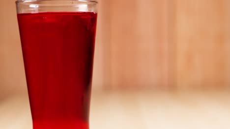 a glass filled with red soft drink