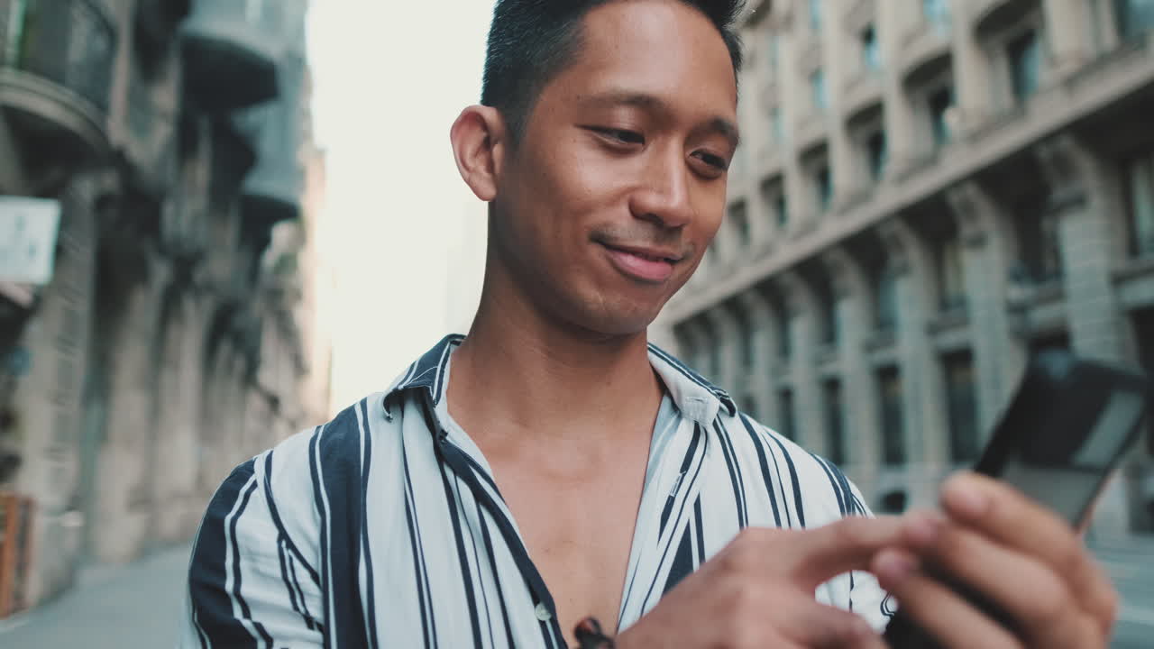 Man using smartphone on city street