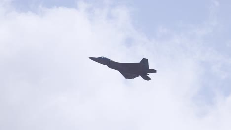 f-22 raptor performs aerial maneuvers against a cloudy sky at avalon airshow, showcasing its stealth and agility