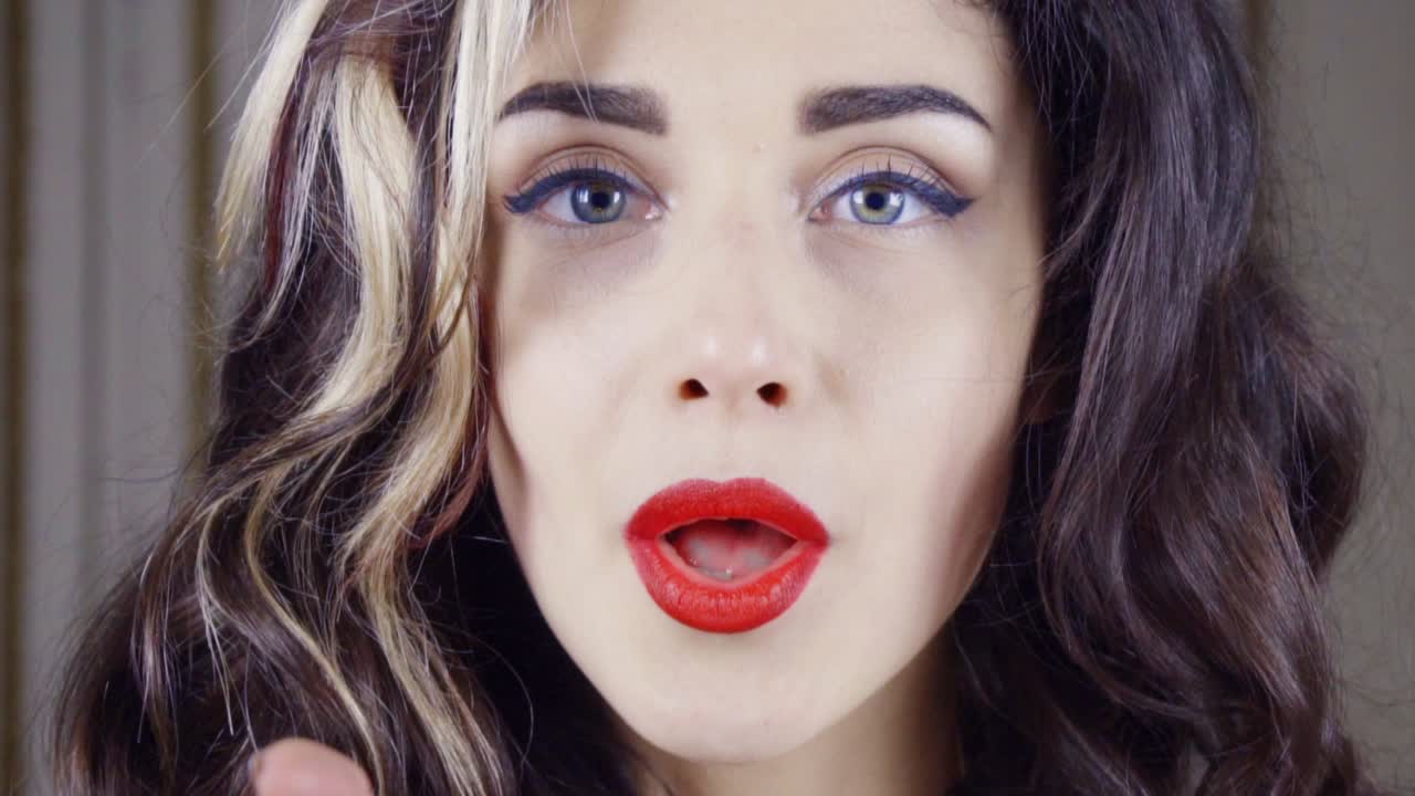 una joven morena sopla confeti dorado