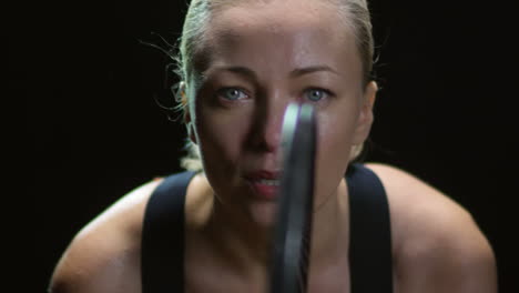 front view of a blonde woman in sportswear, sweating and holding a tennis racket