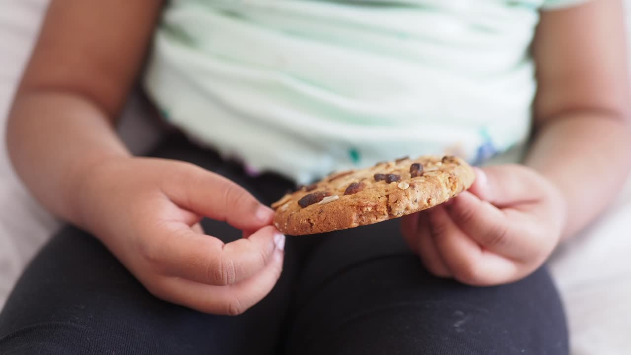 Bambino che mangia un biscotto