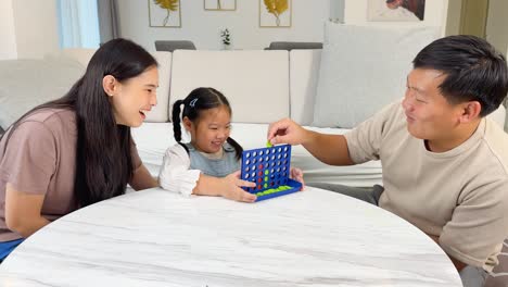 a family enjoys a board game together in a cozy, well-lit living room, fostering connection and joy