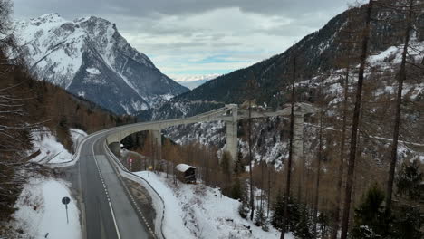 Amplia-Toma-De-Drones-Del-Ultra-Moderno-Puente-Ganter-Entre-Los-Altos-Picos-Suizos-De-Los-Alpes-Cubiertos-Durante-El-Invierno