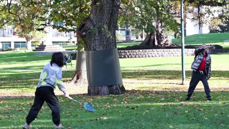 two people playing badminton in the park