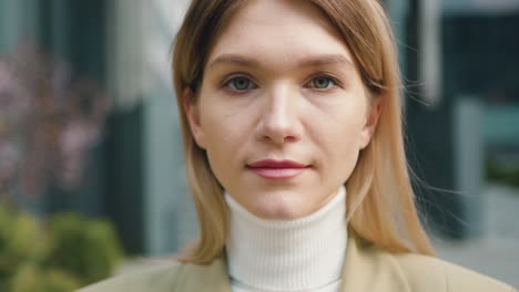 outdoors portrait face female worker in the business district. woman standing in city building background and looking at camera smiling