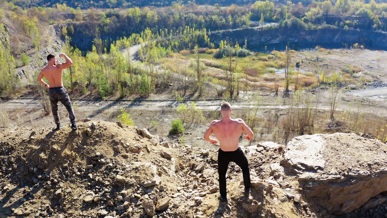 Athletic men posing with muscles. Aerial view of handsome bodybuilders with perfect muscular body posing outdoors