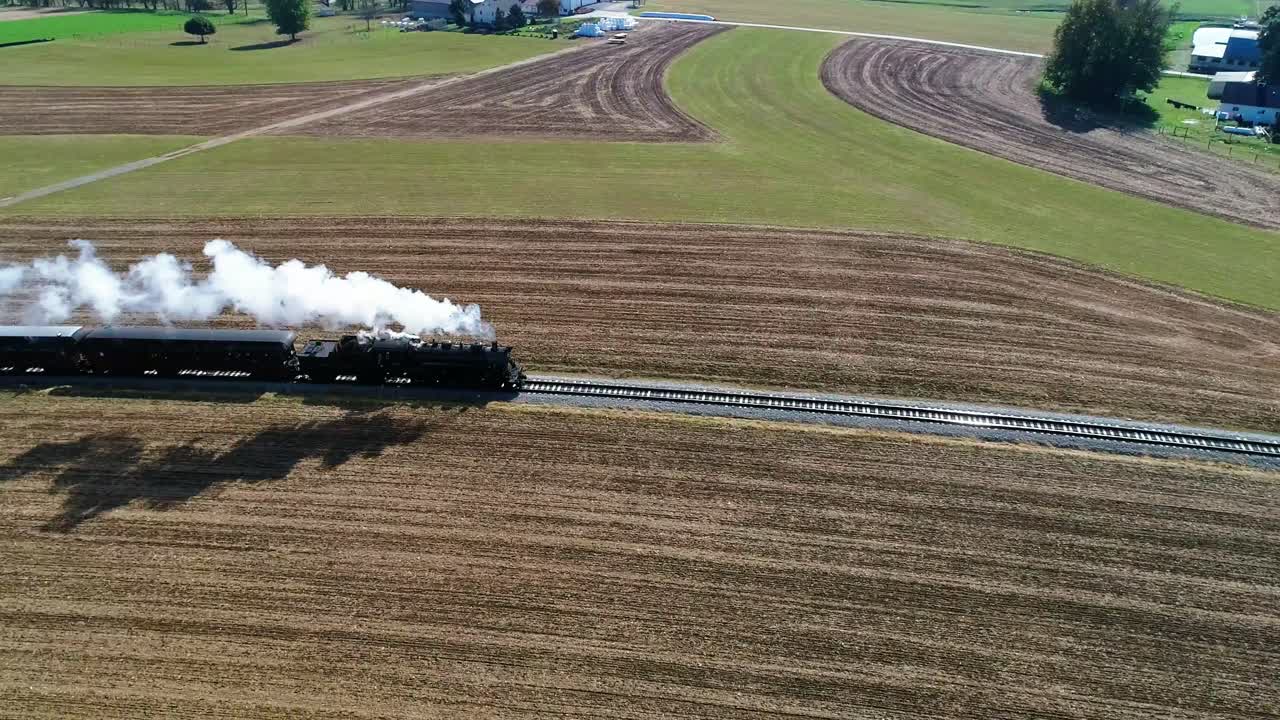 드론으로 본 아미쉬 시골을 따라 연기를 내뿜는 증기 여객 열차