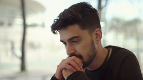 serious man using digital device in outdoor cafe