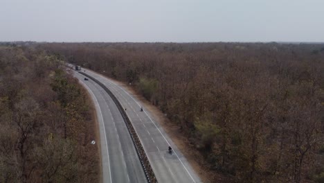 aerial drone shot of the iconic nh44 srinagar to kanyakumari 6 lane highway that cuts through the pench national park with underpass for wild animals to cross, india