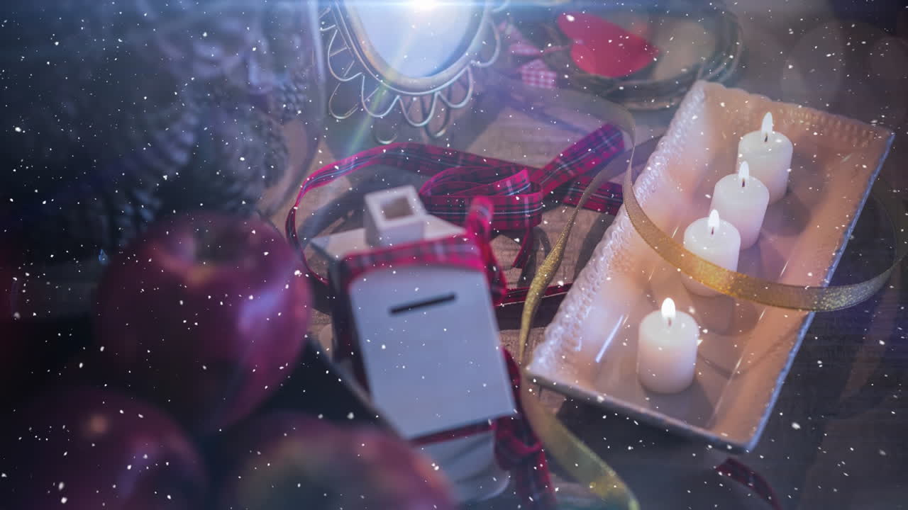 velas y decoración navideña combinadas con la nieve que cae