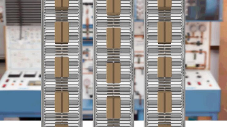 Multiple delivery boxes on conveyor belt against factory in background