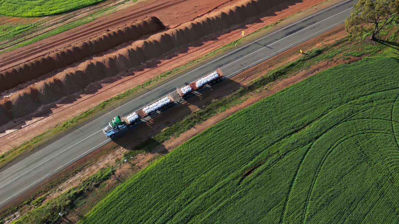 해가 지는 오스트레일리아의 시골 도로에서 가방을 운반하는 화물 트럭의 항공 추적  ⁇  - 위 아래