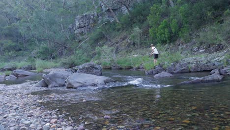 Ein-Mann-Fängt-Eine-Forelle-Aus-Einem-Fluss-In-Der-Australischen-Wildnis