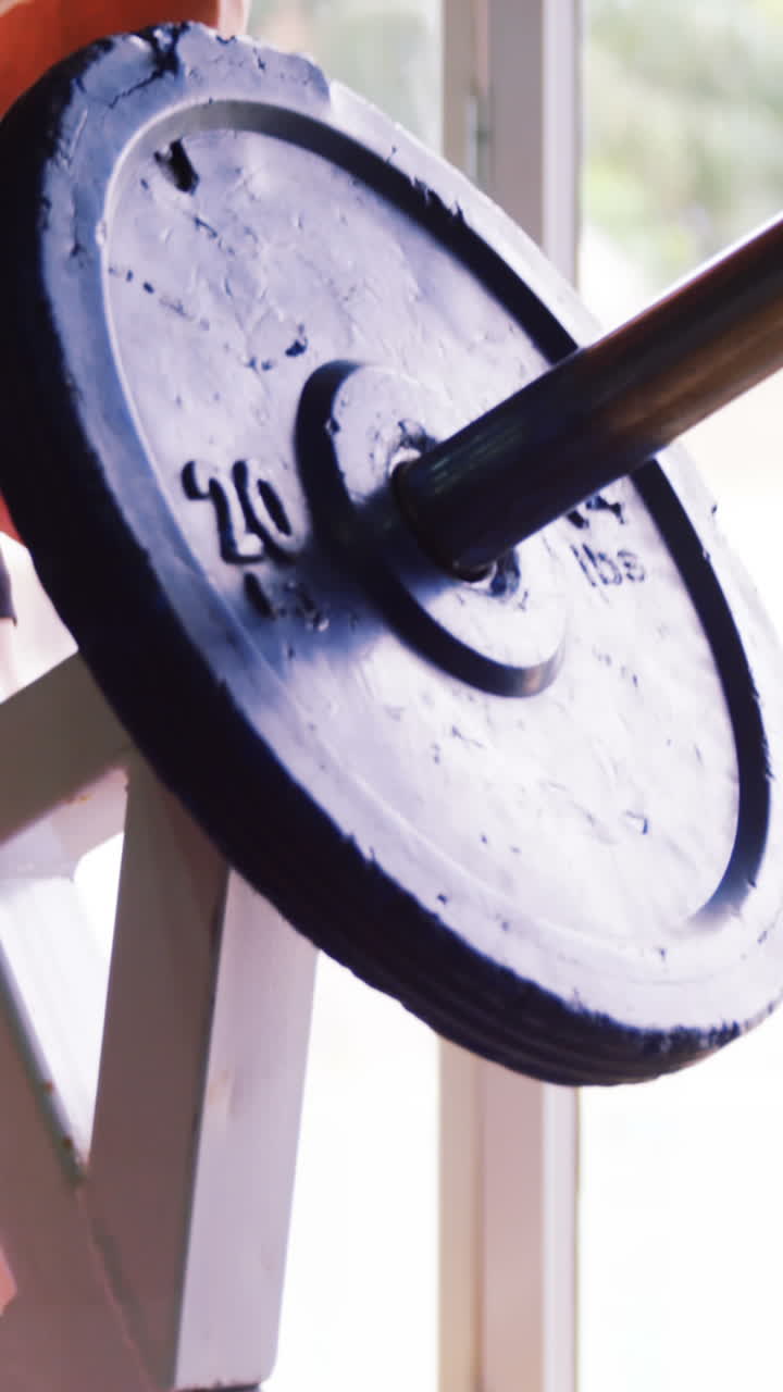 근육이 많은 남자가 바벨을 들어 올리는 기계