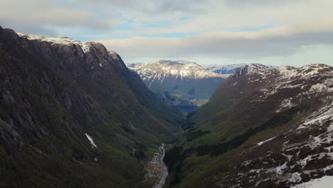 Aerial-dolly-through-the-dramatic-Buar-Valley-with-snow-covered-hillsides