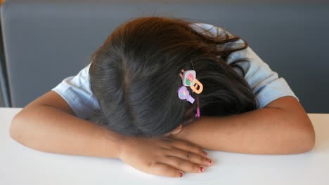 a young girl sleeping at a table