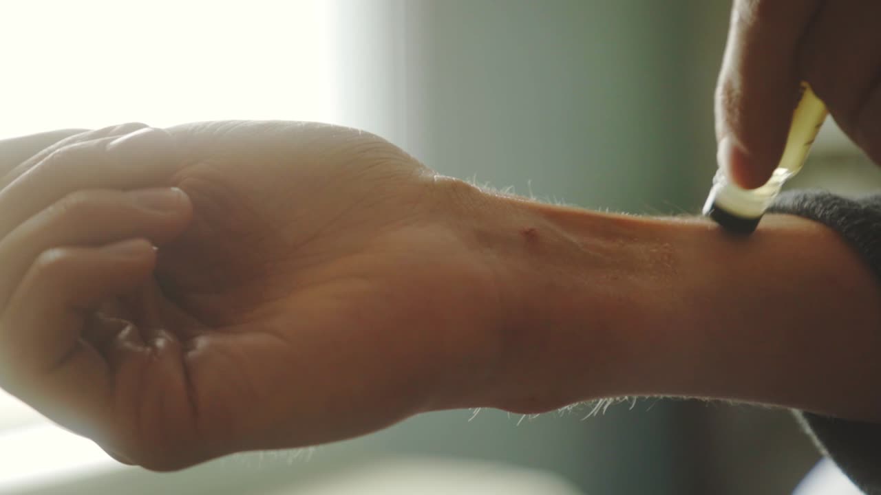 손목에 롤온 향수를 바르는 남자