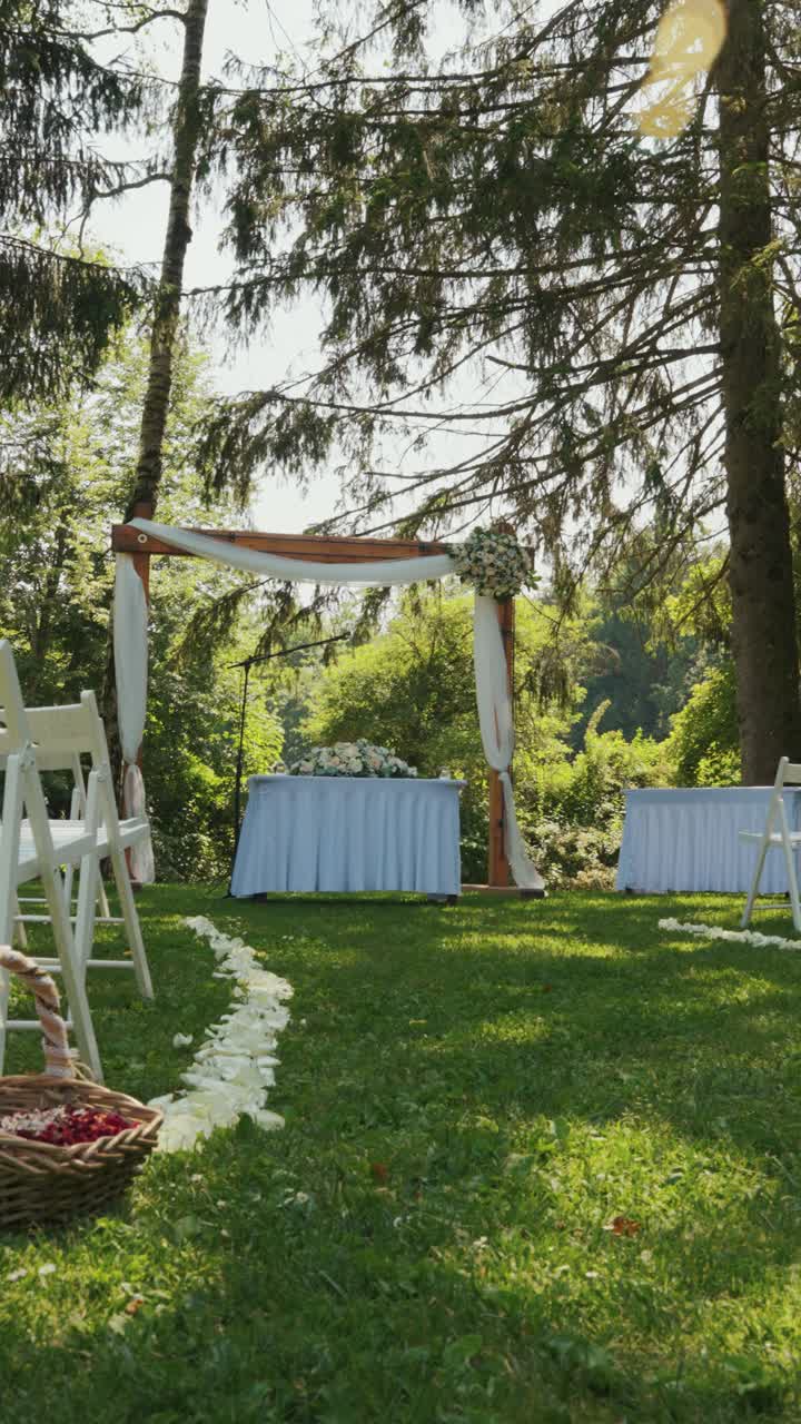 The setup with white chairs and a stage for a wedding in nature.
