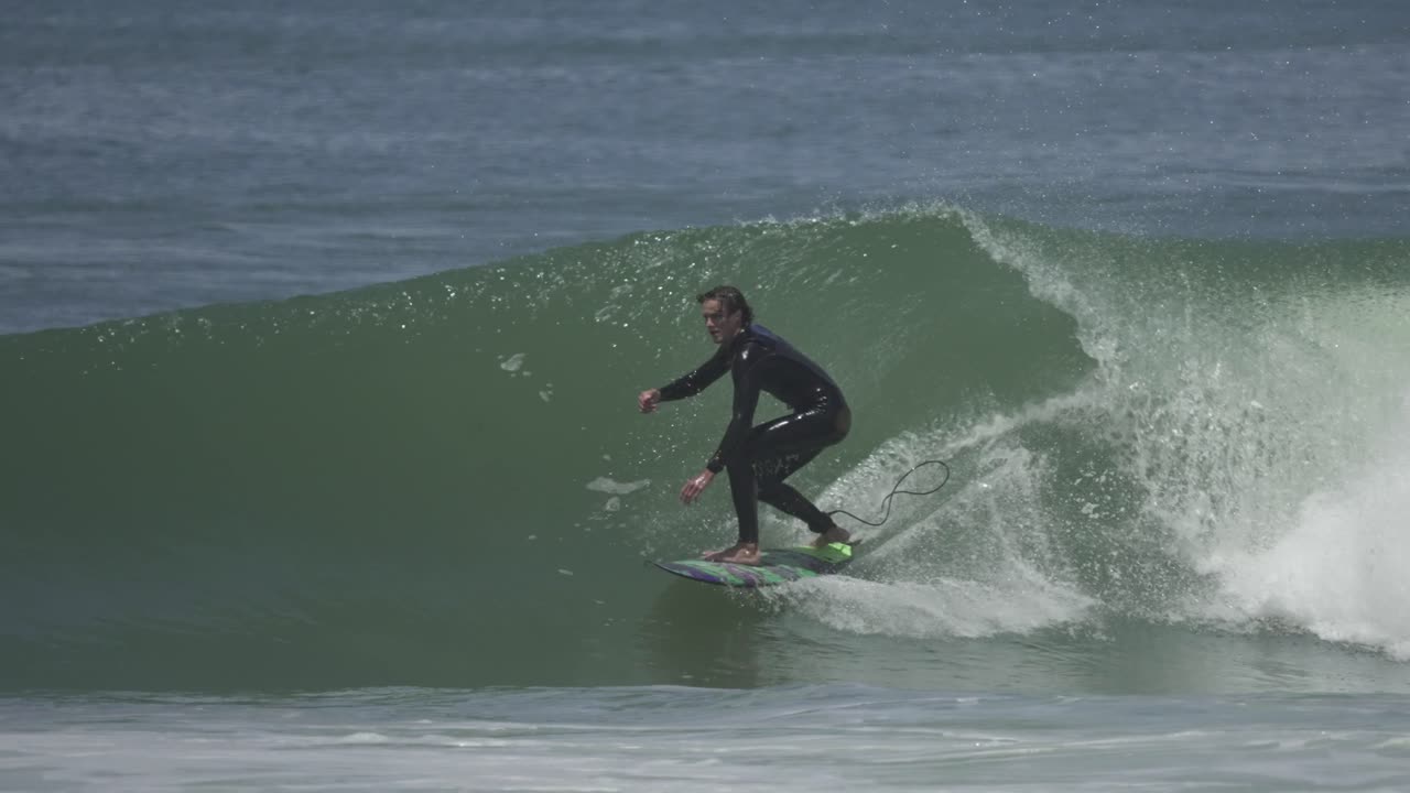 A surfer gets deep inside a hollow green barrel, fully committed, barely visible under the lip a moment of pure tube riding mastery