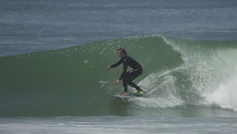 a surfer gets deep inside a hollow green barrel, fully committed, barely visible under the lip a moment of pure tube riding mastery