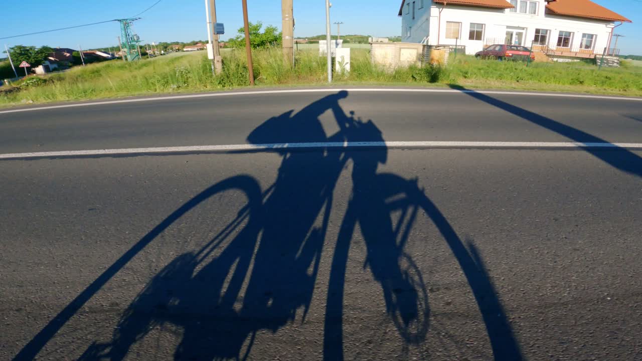 Bikepacking silhouette on asphalt road, travel, bike touring, sunset, motion