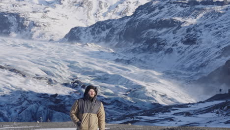 viajero caucásico explorador mochilero caminata en montaña glaciar con nieve paisaje de invierno destino extremo alrededor del mundo