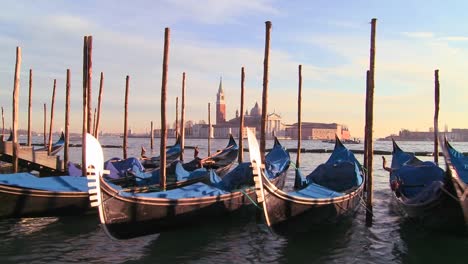 rows of gondolas line a canal in venice italy 1