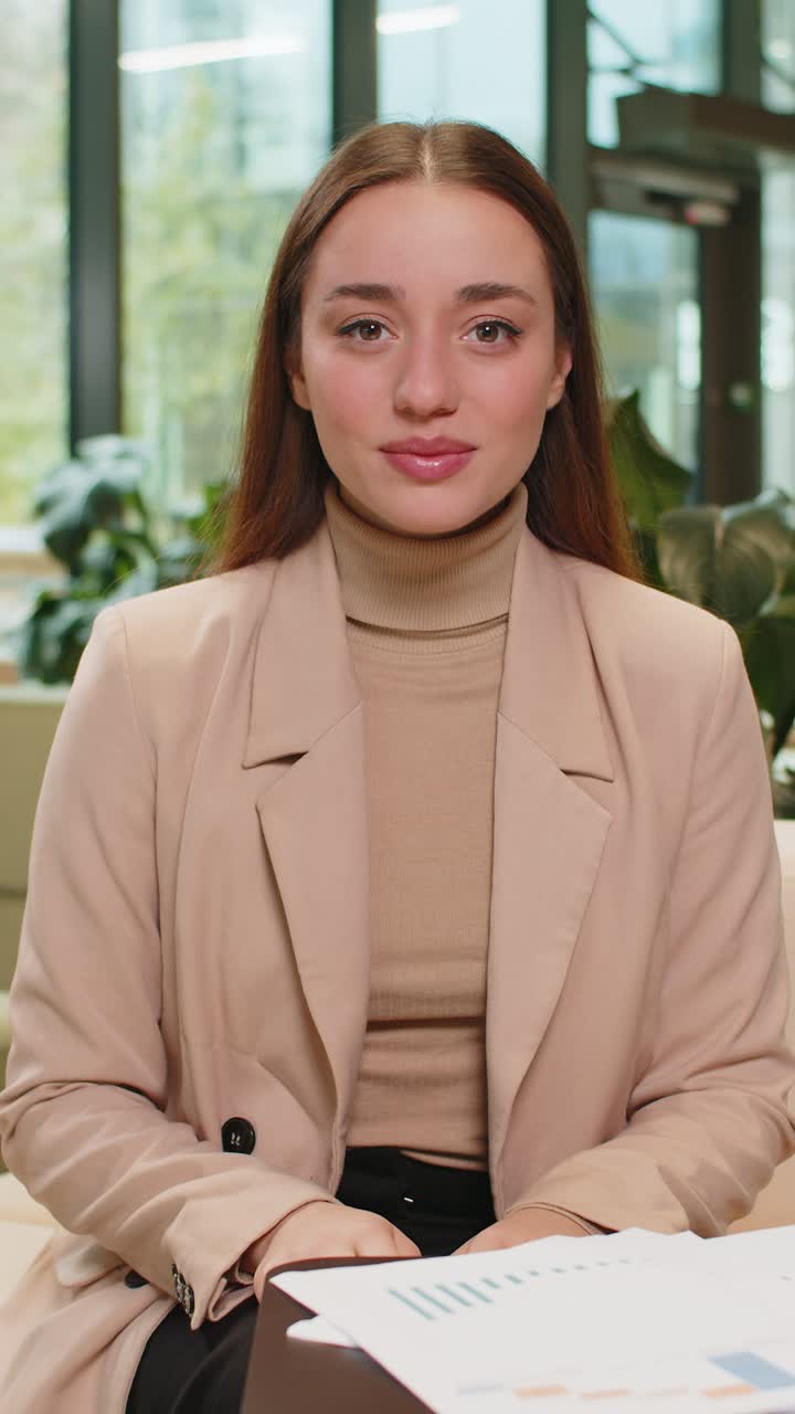 Caucasian young businesswoman lady looking at camera shocked by sudden victory in office lobby