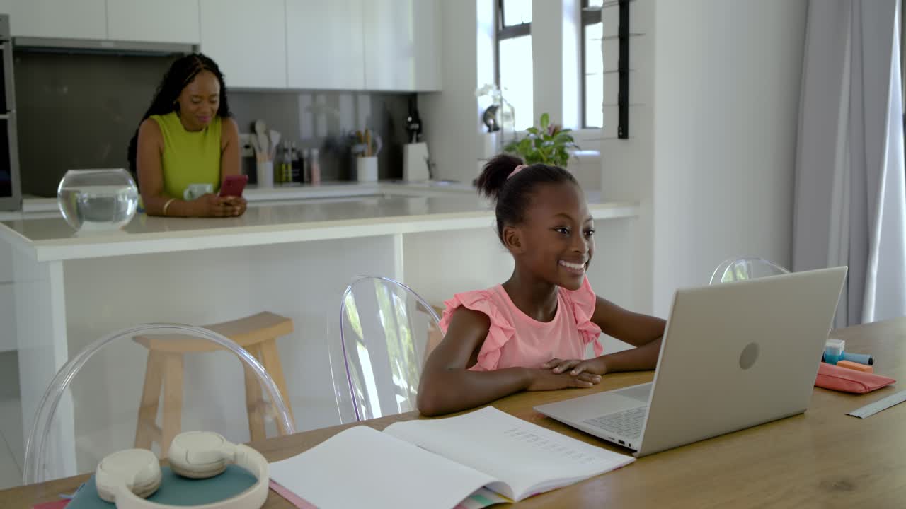 Female mother and daughter joining remote class at home daughter speaking to laptop mother watching