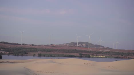 Molinos-De-Viento-Girando-En-El-Desierto-Buen-Clima-De-Dunas-De-Arena-Blanca-En-Mui-Ne,-Phan-Thiet,-Vietnam