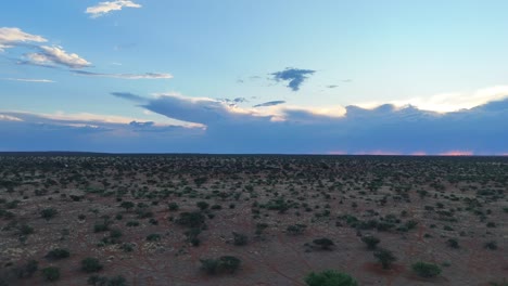 rising drone flight over the semi arid kalahari bushveld, mountains in the background