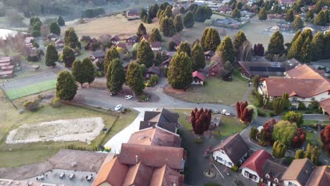 4k drone shot of a swiss style village resort in australia with cottages near a lake