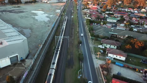 Antenne:-Drohnenaufnahme-Verfolgt-Einen-Zug,-Der-Sich-Schnell-Durch-Ein-Industrielles-Vorstadtgebiet-In-Sydney,-NSW,-Bewegt