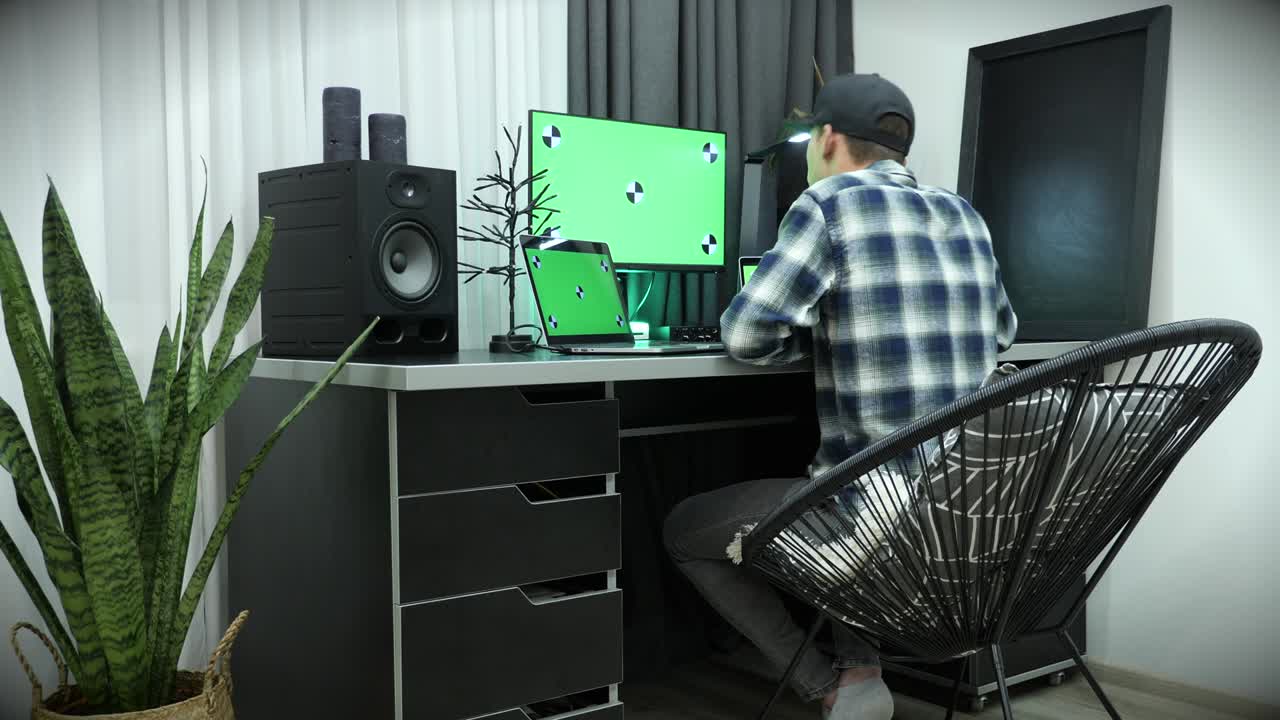 녹색 크로마 키 스크린과 함께 큰 디스플레이를 가진 컴퓨터에서 일하는 남자, 키보드에서 타이핑. 글로벌 비즈니스 연구. 녹색 스크린을 가진 노트북을 사용하는 남성 프리랜서