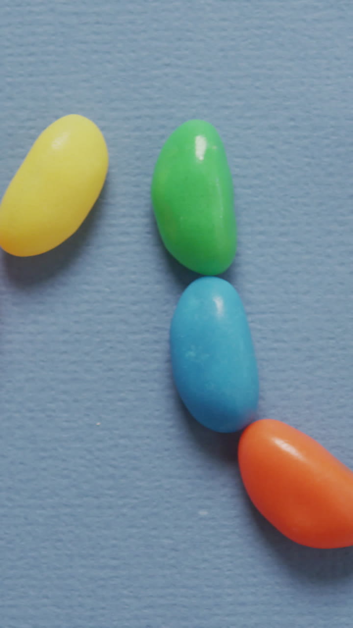 video de vista aérea de un texto delicioso formado por dulces multicolores sobre un fondo azul