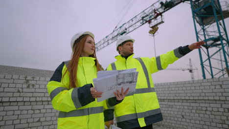 young female civil engineer and foreman are discussion construction plan in building site