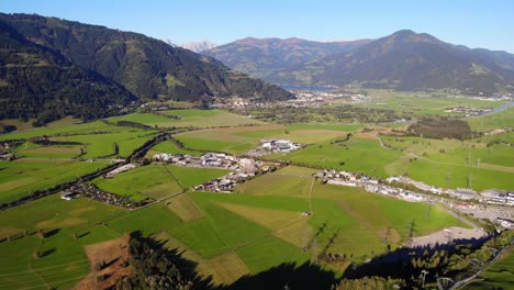 increíbles campos verdes y un pueblo al pie de la montaña en kaprun austria - toma aérea