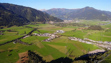 amazing green fields and village in the foot of the mountain in kaprun austria - aerial shot