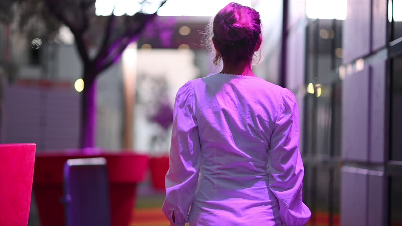 Woman in white dress posing in Cannes in purple lights, France
