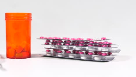 close-up of various pills and tablets in blister packs and an orange bottle