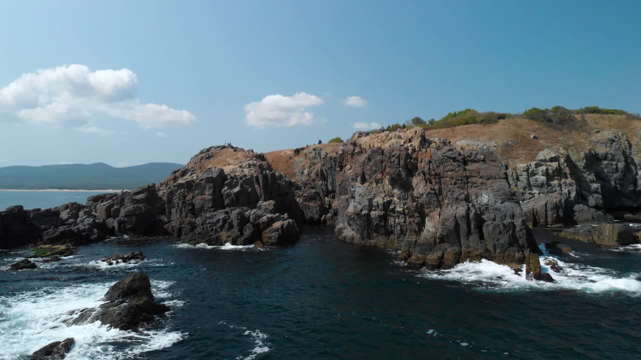 toma aérea de grandes rocas en el mar junto a la orilla en un día soleado de verano